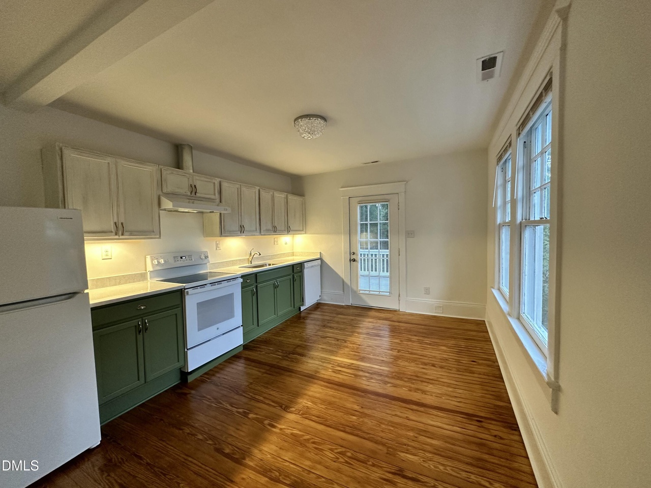 Renovated kitchen with sage-green lower cabinets, white uppers, a white range, and original heart-pine floors